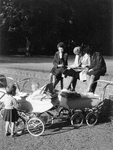 361081 Afbeelding van enkele moeders met hun kinderen en kinderwagens in een park.